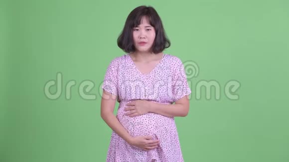 穿着衣服的亚洲孕妇看着悲伤和哭泣视频的预览图