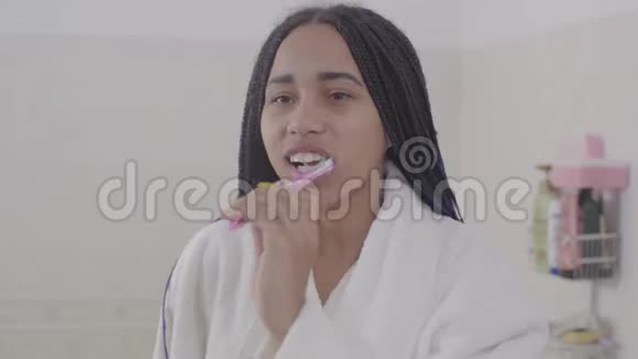 年轻的非洲裔美国妇女与可怕的刷牙肖像可爱的少女在早上准备视频的预览图