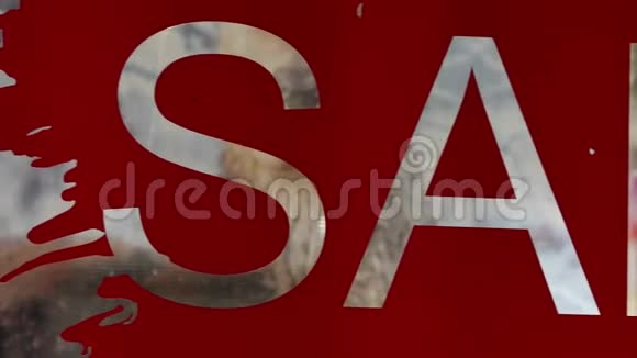 红色乙烯基贴花在商店橱窗的玻璃上贴上文字销售符号反演视频的预览图
