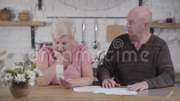 可悲的白种人女人和丈夫一起付账老人使妻子平静下来微笑着配偶定居视频的预览图