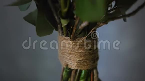 兴趣爱好专业花店用麻绳系着的花柄制作了一束漂亮的花供出售视频的预览图
