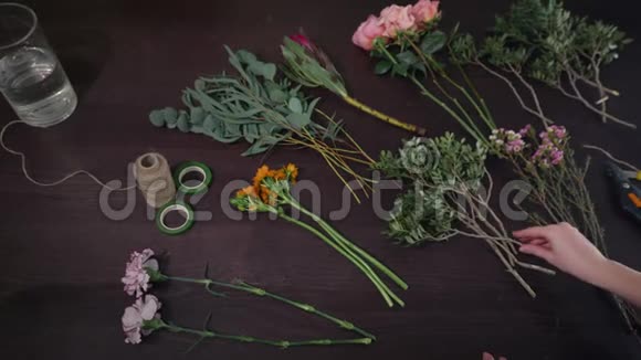 爱好专业的花艺师在现代的花艺沙龙工作制作一束创意的鲜花出售视频的预览图