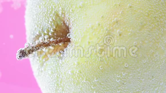 新鲜采摘的绿苹果和水滴水下水中的水果健康饮食观视频的预览图