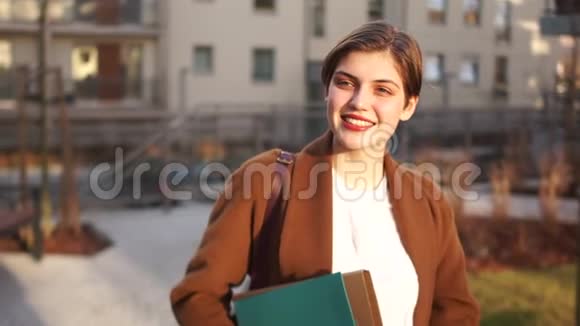 年轻的女律师或公证人在城市景观的背景下手里拿着文件夹在工作的房地产经纪人实际视频的预览图