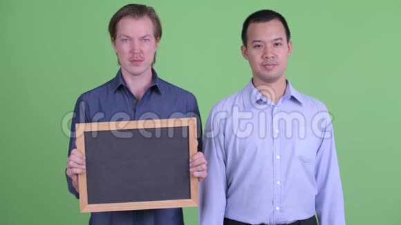 两个快乐的多民族商人拿着黑板竖起大拇指视频的预览图