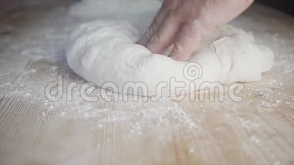 在家里用一张轻木桌上用白面粉捏披萨面团视频的预览图