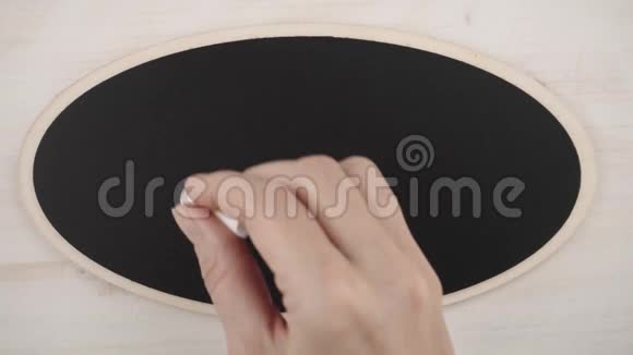 俯视图一个女人用白色粉笔在黑板上写字视频的预览图