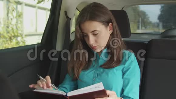 女人在车上写私人组织者的笔记视频的预览图