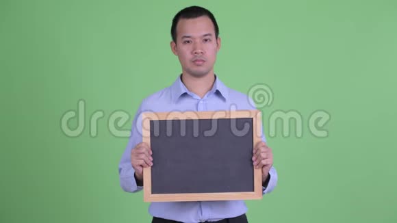 快乐的亚洲商人拿着黑板看上去很惊讶视频的预览图