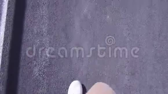 穿着白色运动鞋的人走在沥青路上第一人称视频视频的预览图