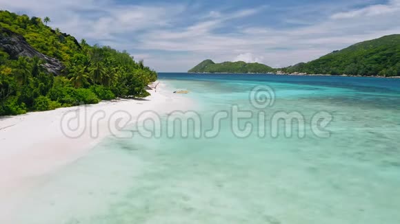 带孤舟原始白沙和蓝绿色海洋泻湖的热带异国海滩空中4k镜头视频的预览图