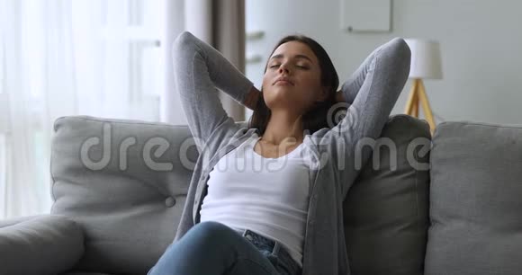 舒舒服服地躺在沙发上享受幸福的美丽女孩视频的预览图