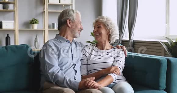 快乐的老爷爷奶奶夫妇聊天拥抱沙发放松视频的预览图