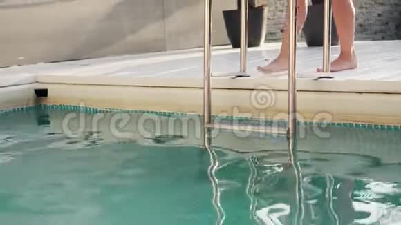 一个穿着泳衣的年轻女人下楼去游泳池视频的预览图