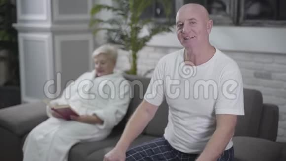 快乐成熟的白种人男人回头看妻子回头看相机一位金发碧眼的老女人视频的预览图