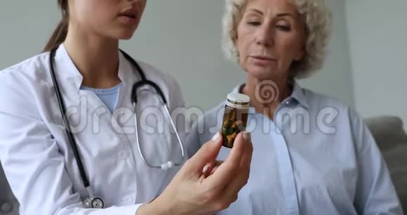 女医生药剂师拿着给老年病人开药瓶视频的预览图