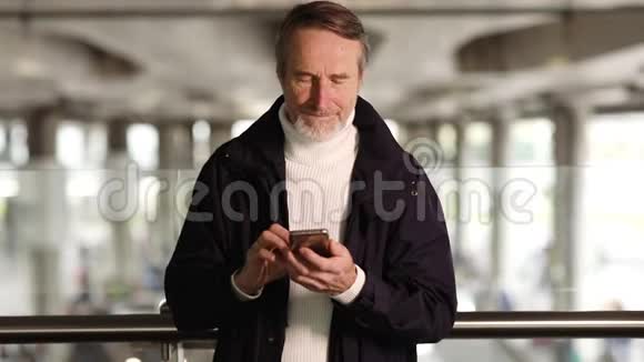 站在户外打手机的老人视频的预览图