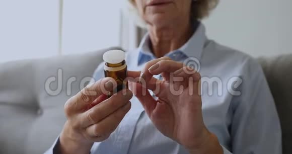老妇人从手上的瓶子里读出处方倒药丸视频的预览图