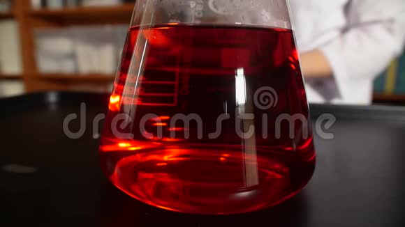 干冰掉进装有红色化学液体的瓶子里化学反应发生在烧瓶中进行实验视频的预览图