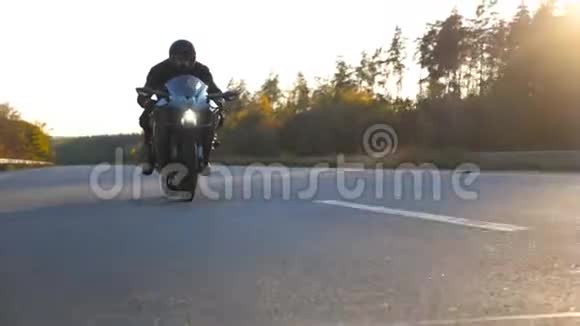 在高速公路上骑着现代运动摩托车骑着头盔的年轻人的正面景色骑摩托车的摩托车视频的预览图