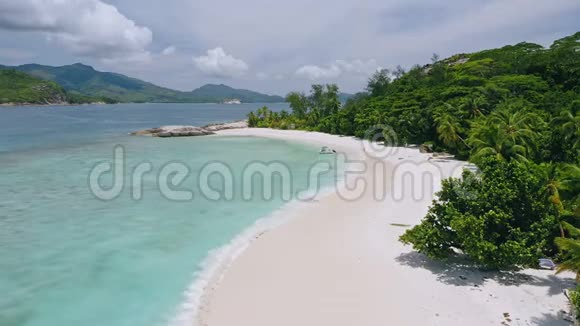 在热带奇异的蓝色泻湖中停泊的孤独旅游船的空中近景清澈的蓝色海水和视频的预览图