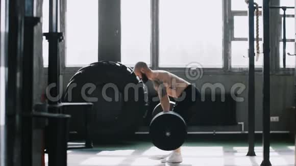 侧面观察年轻的白种人举重运动员男子在健身房锻炼杠铃重量成长和动力视频的预览图