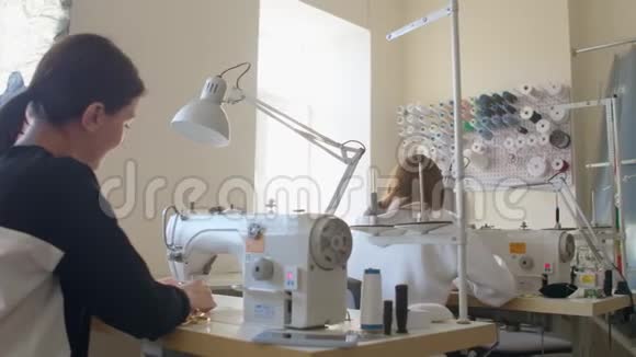 两名女裁缝在服装裁剪车间工作在缝纫机上工作设计师的创造视频的预览图