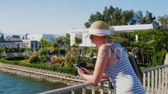 带着电话的游客站在西班牙埃姆普里布拉瓦运河上的桥上概念欧洲之旅视频的预览图