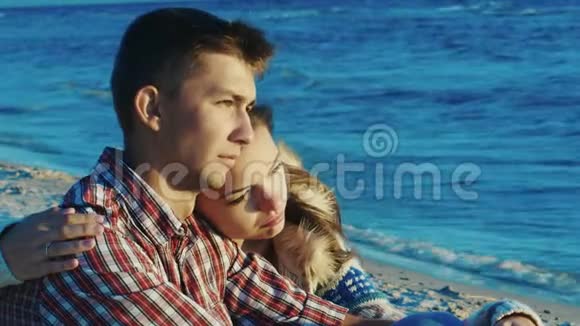 浪漫的情侣在海滩上放松她紧紧抓住了那个人秋天晴朗多风的一天视频的预览图