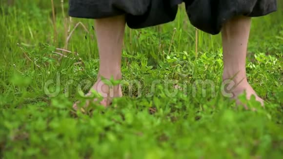 一个练习者在户外草地上腿的特写在气功练习中赤脚穿越a的概念视频的预览图