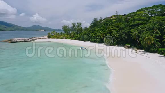 在热带异国情调的僻静海滩上带着船的孤独旅游夫妇的鸟瞰蓝色泻湖清澈的蓝色海洋视频的预览图