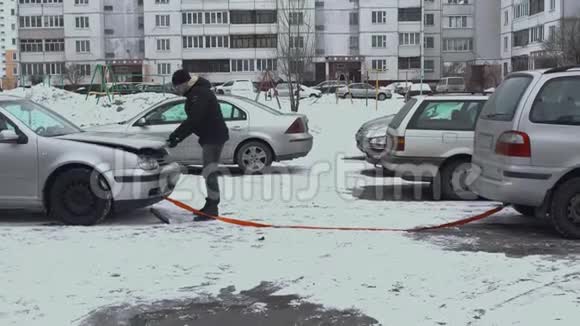 一个人进入一辆破车被另一辆汽车用一个灵活的绳子拴住冬季白天视频的预览图