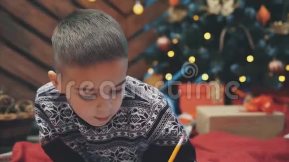 小男孩的特写确定他一整年都表现得很好正在写信给圣诞老人以获得礼物视频的预览图