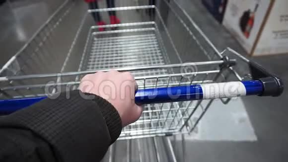 超市里的顾客滚动一个购物车视频的预览图