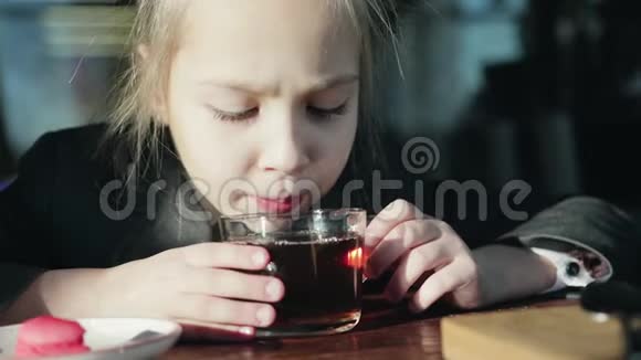 快乐可爱的学生拿着饮料吃早餐吹着热茶的小女孩视频的预览图