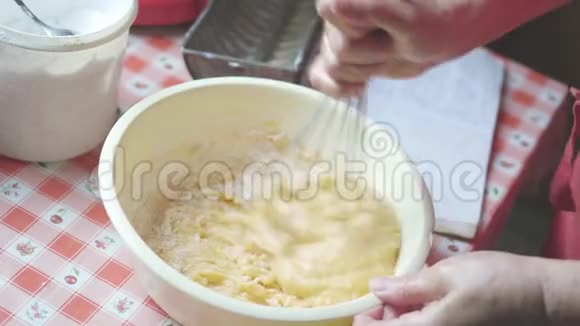 家庭主妇把面团和传统的厨房用具混合起来做消遣视频的预览图
