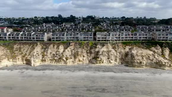 加州德尔玛北海滩带房屋和蓝色太平洋海岸悬崖的鸟瞰图视频的预览图