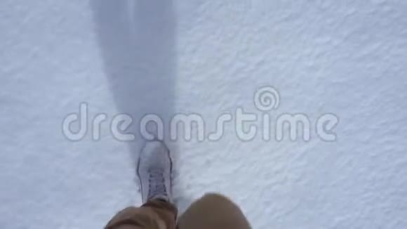 冬天穿白色运动鞋的人在雪地里散步视频的预览图