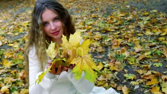 秋天的女孩吹着一束落叶视频的预览图