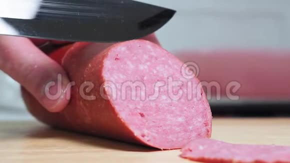 用刀切熏香肠香肠切片放在切割板的特写上把肉片煮熟视频的预览图