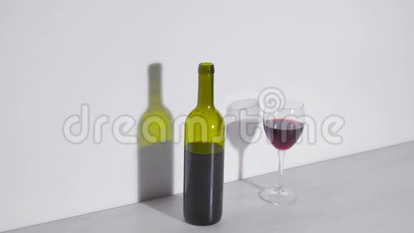 概念镜头一瓶葡萄酒和一杯白色背景视频的预览图