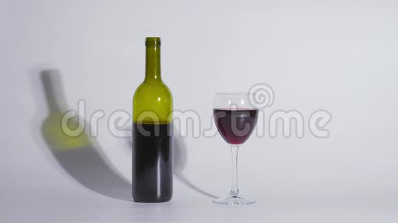 概念镜头一瓶葡萄酒和一杯白色背景视频的预览图