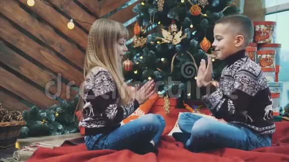男孩和女孩笑的视频一起玩乐趣玩拍手游戏的木制圣诞背景视频的预览图