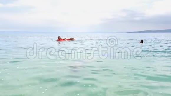 少女在游泳床垫和潜水面具上享受海水浴视频的预览图