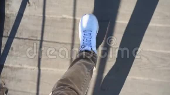 阳光明媚的一天穿着白色运动鞋的人沿着街道走着第一人称视频视频的预览图