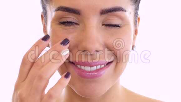 美丽的女人用奶油滋润脸视频的预览图