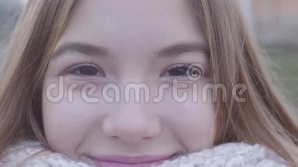 极端的特写微笑的白人金发女孩棕色的眼睛看着相机户外可爱少年画像视频的预览图