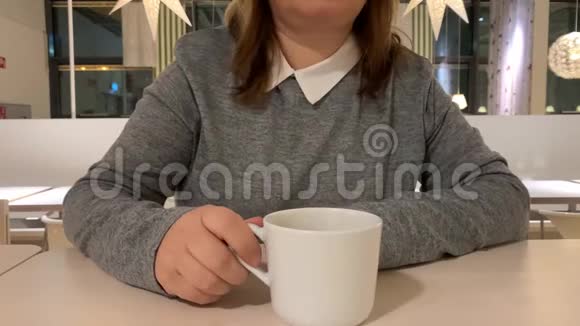 咖啡馆里的女孩喝咖啡白杯里有牛奶餐饮理念视频的预览图