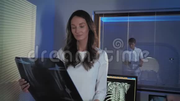 两位医生站在断层扫描室研究x射线图片工作中的专业人士视频的预览图