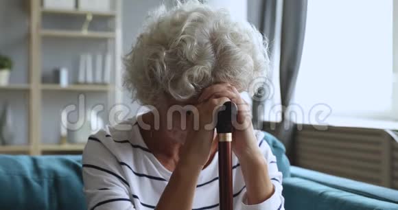 悲伤疲惫的老太太独自坐在沙发上视频的预览图